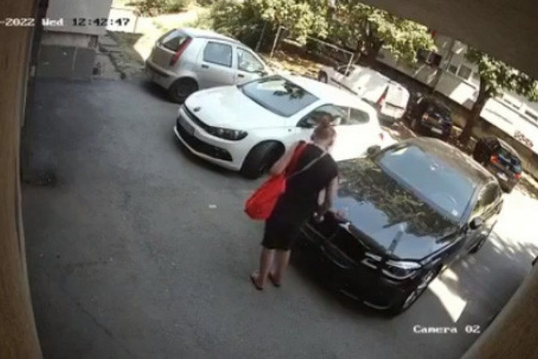 Krađa u po bela dana na Voždovcu: Žena prvo osmotrila situaciju, pa nonšalantno otkinula znak sa BMW-a   (VIDEO)