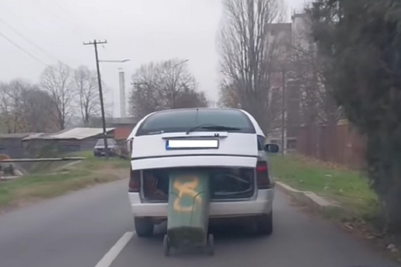 "Vežba vožnju sa pomoćnim točkićima": Neobična scena  u Beočinu - zakačio kantu za đubre za automobil (VIDEO)