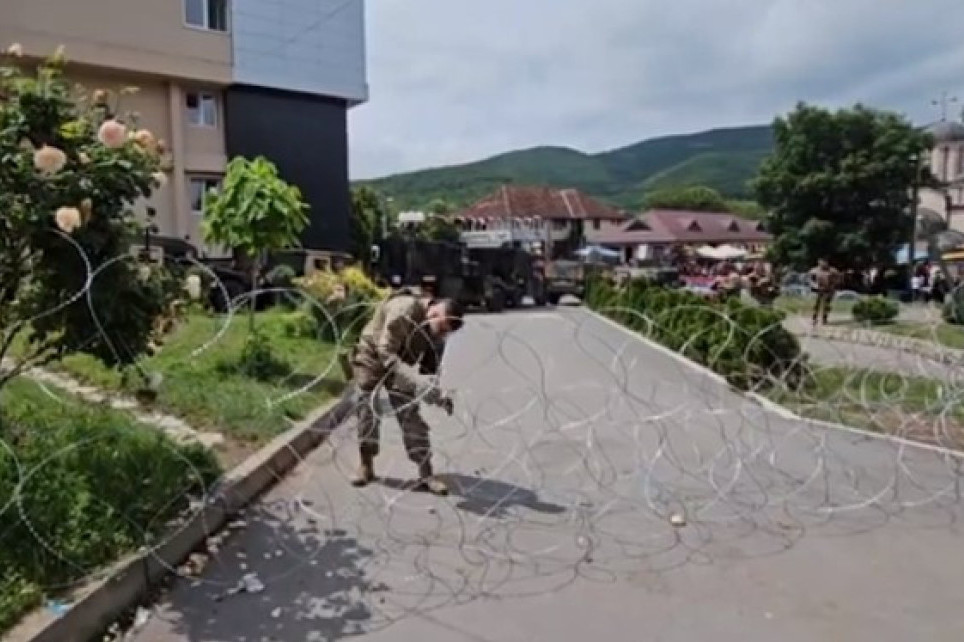 Pripadnici Kfora u Leposaviću skidaju deo bodljikave žice ispred zgrade opštine