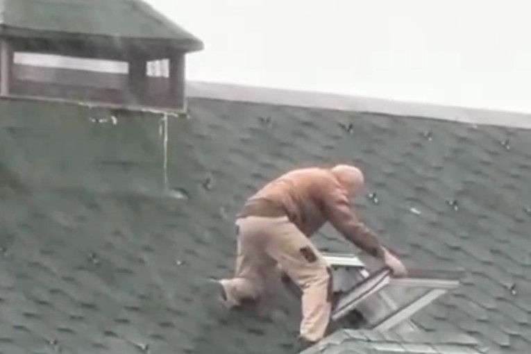 Ludost ili hrabrost: Beograđanin popravlja krov dok napolju duva olujni vetar i pljušti kiša (VIDEO)