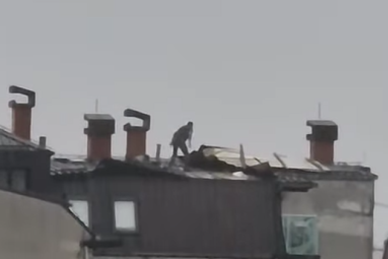 Neverovatna scena: Dok nevreme razara Kragujevac, čovek popravlja krov zgrade (VIDEO)